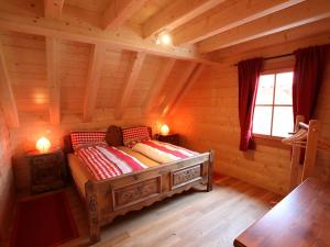 ein Schlafzimmer mit einem Bett in einem Blockhaus in der Unterkunft Apartment Lärche by Interhome in Schönbronn