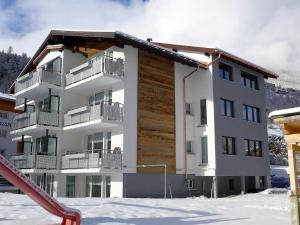 a apartment building in the snow with a slide at Apartment Amici-2 by Interhome in Saas-Grund