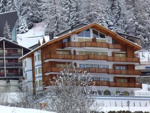 a large building with a snow covered mountain at Apartment Edelweiss A-1 by Interhome in Leukerbad +9 photos