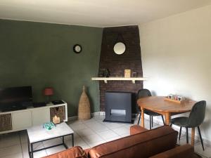 ein Wohnzimmer mit einem Tisch und einem Kamin in der Unterkunft Biedermeier in Born