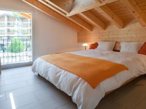 a bedroom with a large bed and a large window at Apartment Edelweiss A-1 by Interhome in Leukerbad