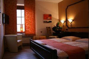 a bedroom with a bed and a chair and a window at Le Pavillon in Echternach