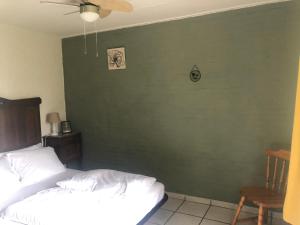 een slaapkamer met een groene muur met een bed en een stoel bij Biedermeier in Born