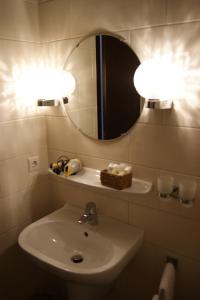 een badkamer met een wastafel en een spiegel bij Le Pavillon in Echternach