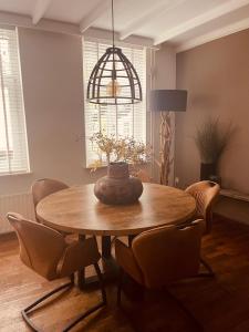 een eettafel met stoelen en een vaas erop bij Vakantie appartement Sunndays in Valkenburg