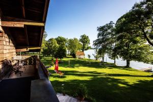 a view of a yard with a house and a lake at Ferienwohnungen Am Strandbad in Chieming