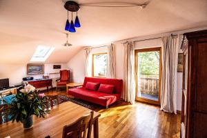 a living room with a red couch and a table at Ferienwohnungen Am Strandbad in Chieming