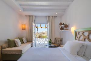 a bedroom with a bed and a couch and a patio at San Antonio Summerland in Mýkonos City