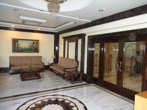 een woonkamer met een bank en een stoel bij Florence Inn in New Delhi