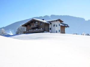 une maison au sommet d'une colline enneigée dans l'établissement Apartment Kitzsteinhorn by Interhome, à Saalfelden