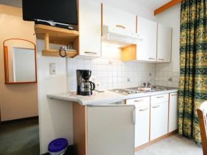 a small kitchen with white cabinets and a sink at Apartment Falkner-13 by Interhome in Oberlängenfeld