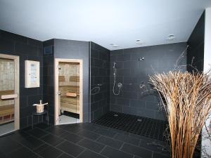 ErlbergにあるApartment Haus Sonne by Interhomeの黒いタイルの黒いバスルーム(シャワー付)
