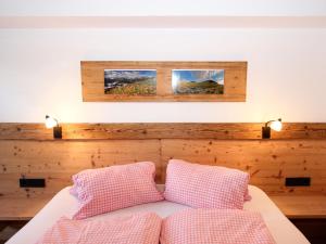 a bedroom with a bed with two pink pillows at Apartment Marina-1 by Interhome in Mühlfeld