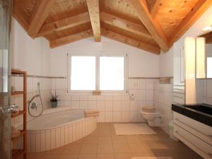 a bathroom with a tub and a toilet and a window at Holiday Home Linnehan by Interhome in Fügen