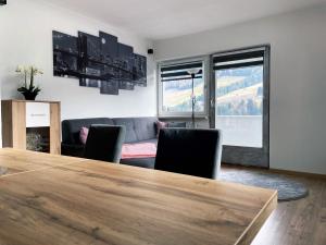 ein Wohnzimmer mit einem Tisch, Stühlen und einem Sofa in der Unterkunft Ferienwohnung Sunhill in Sellrain