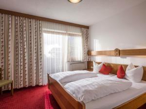 ein Schlafzimmer mit einem großen weißen Bett mit roten Kissen in der Unterkunft Apartment Christian by Interhome in Maurach
