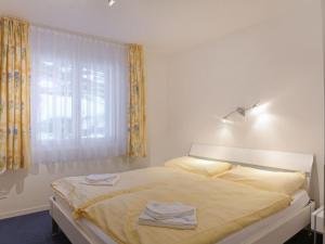 a bedroom with a bed with two towels on it at Apartment Goldenhorn Apt-F by Interhome in Wengen