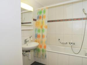 ein Bad mit einem Waschbecken und einem Duschvorhang in der Unterkunft Apartment Goldenhorn by Interhome in Wengen