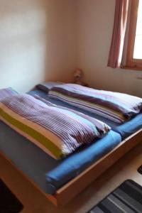 a bed with two pillows on it in a room at Apartment Adlerhorst by Interhome in Adelboden