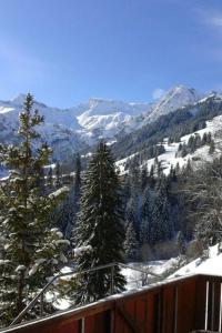 a view of a snow covered mountain with trees at Apartment Adlerhorst by Interhome in Adelboden