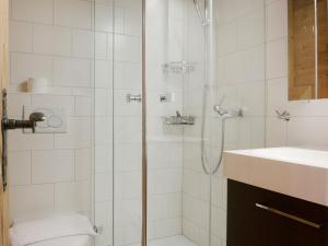 a bathroom with a shower with a toilet and a sink at Apartment Sulegg by Interhome in Wengen