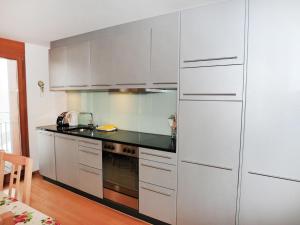une cuisine avec des placards blancs et un comptoir noir dans l'établissement Apartment Eden by Interhome, à Wengen