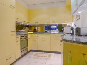 een grote keuken met witte apparaten en gele kasten bij Apartment Bella Vista Apt- No- 09 by Interhome in Wengen