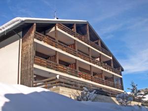 een gebouw bovenop een met sneeuw bedekte helling bij Apartment Centaure A RS 3 by Interhome in Ovronnaz
