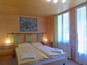 a bedroom with a large bed and a window at Apartment Schweizerhof-1 by Interhome in Wengen