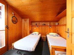2 łóżka w niewielkim pokoju z drewnianymi ścianami w obiekcie Apartment Butte aux Noëls 206 by Interhome w mieście Verbier