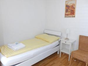 una piccola camera con letto e sedia di Apartment Am Acher II by Interhome a Wengen