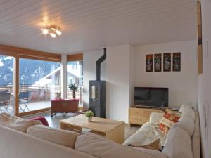 a living room with a couch and a tv at Apartment Am Acher II by Interhome in Wengen