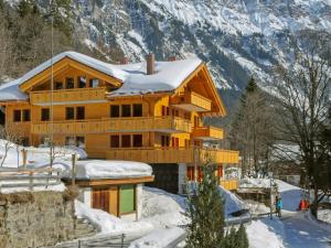een houten huis in de sneeuw met een berg bij Apartment Bergfrieden Apt- 2 by Interhome in Wengen
