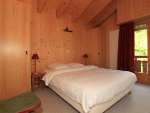 a bedroom with a large bed in a wooden room at Apartment Fénestral 301 by Interhome in Ovronnaz