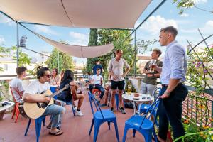 un grupo de personas sentadas en un patio tocando instrumentos en Hotel Azzi, en Florencia