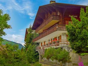 a building with balconies on a hill with trees at Apartment Bergkristall by Interhome in Wengen