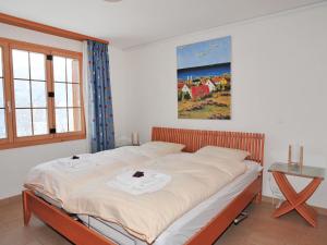 ein Schlafzimmer mit einem großen Bett mit weißer Bettwäsche in der Unterkunft Apartment Panorama by Interhome in Wengen