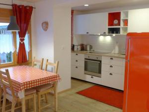 a kitchen with a table and a red refrigerator at Apartment Chalet Almisräba by Interhome in Grindelwald