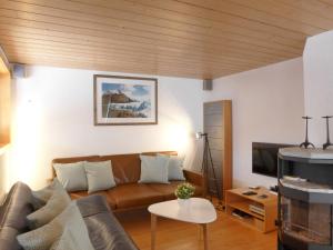 a living room with a couch and a tv at Chalet Wätterlücke by Interhome in Wengen