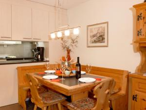 a kitchen with a wooden table with a bottle of wine at Apartment Schoneggacher Apt- S by Interhome in Wengen +17 photos