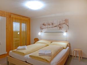 a bedroom with a large bed with white sheets at Apartment Schoneggacher Apt- S by Interhome in Wengen