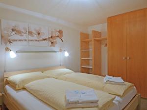 ヴェンゲンにあるApartment Schoneggacher by Interhomeのベッドルーム1室(大型ベッド1台、木製キャビネット付)