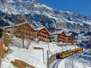 a train on the tracks in front of a mountain at Apartment Primula by Interhome in Wengen