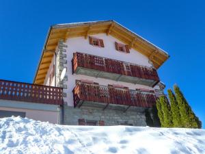 ein Gebäude mit roten Balkonen im Schnee in der Unterkunft Holiday Home Le Dahu by Interhome in Nendaz