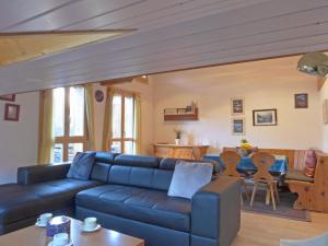 uma sala de estar com um sofá azul e uma mesa em Apartment Breithorn-Residence-3 by Interhome em Wengen