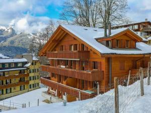 a wooden house with snow on the roof at Apartment Roossihuus by Interhome in Wengen