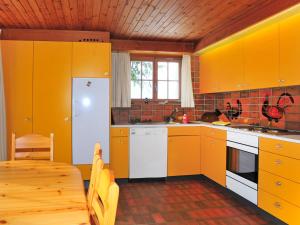 ヴェンゲンにあるChalet Arche by Interhomeのキッチン(黄色のキャビネット、木製テーブル付)
