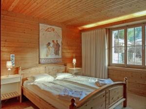 ein Schlafzimmer mit einem großen Bett in einem Holzzimmer in der Unterkunft Chalet Arche by Interhome in Wengen