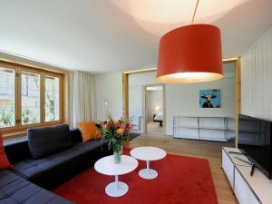 uma sala de estar com um sofá e uma mesa em Apartment Firstli by Interhome em Lenk