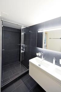 y baño con lavabo, ducha y espejo. en Apartment Firstli by Interhome en Lenk